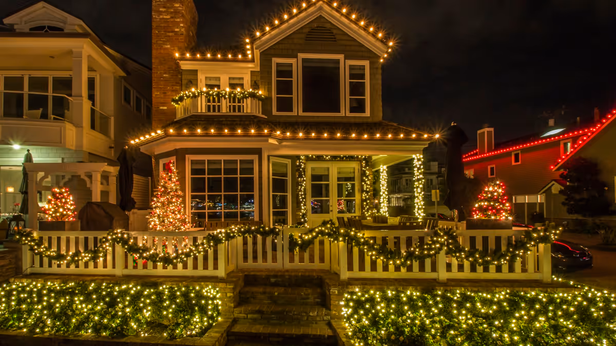 Luces cálidas colgantes iluminan una fachada durante la noche