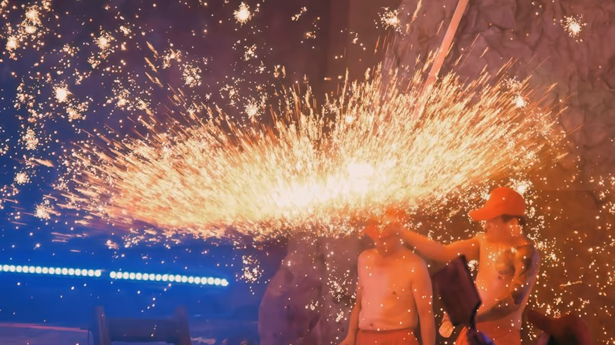 Artistas rodeados por una lluvia de chispas en escenario oscuro