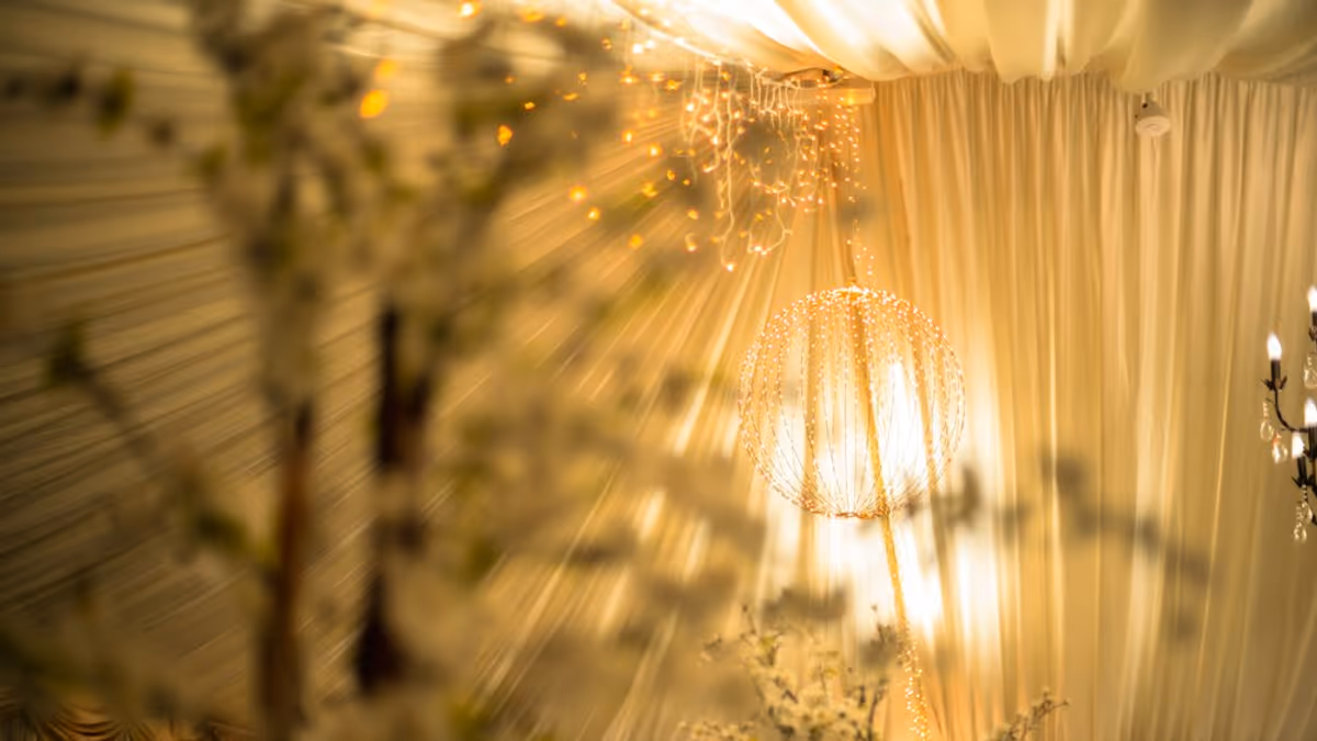 Salón decorado con luces cálidas colgantes y mesas preparadas