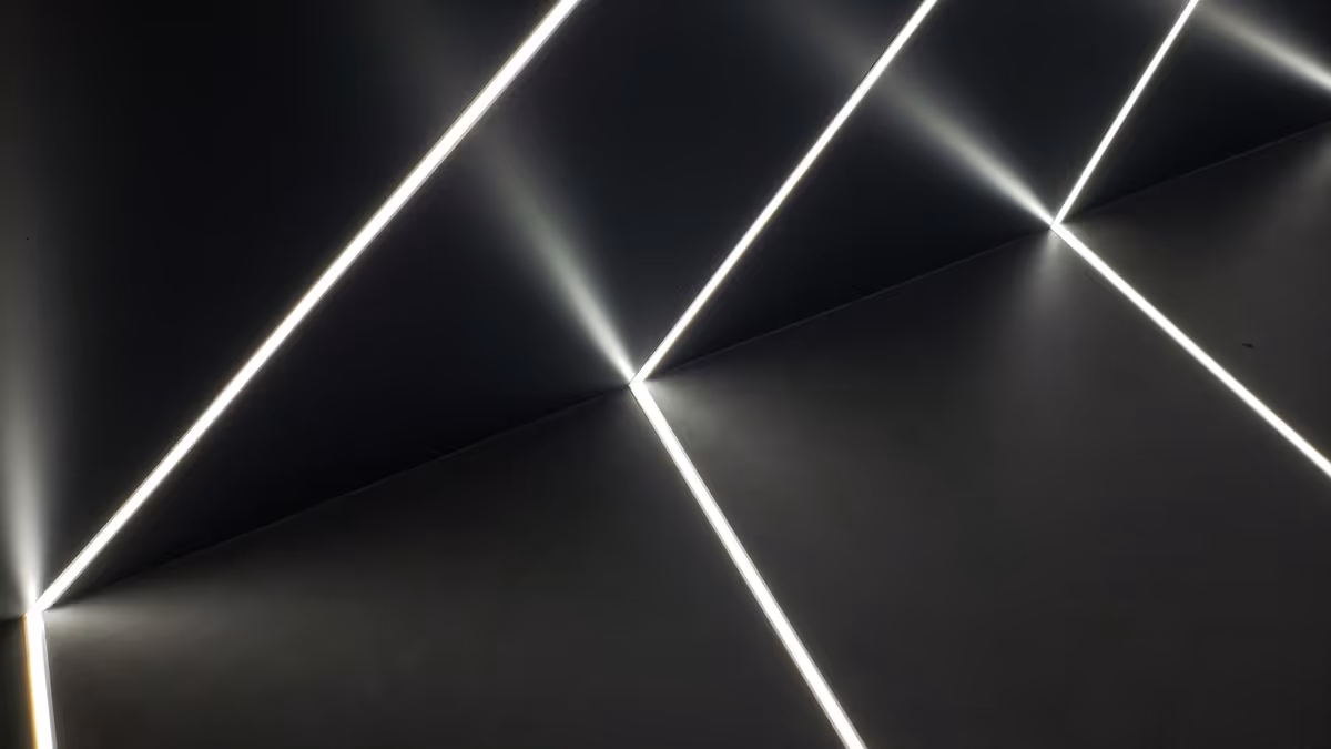 Líneas de luz blanca proyectadas sobre muros oscuros con ángulos marcados