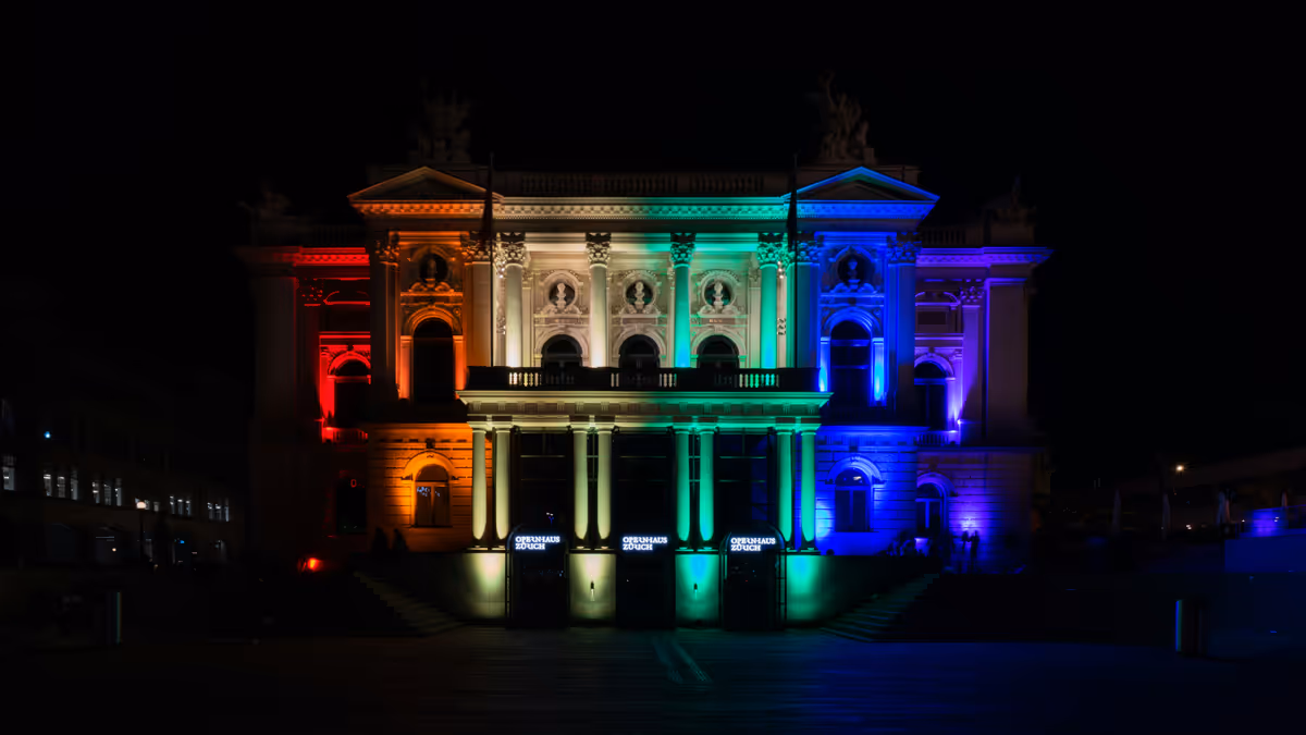 Fachada iluminada con franjas verdes y azules durante la noche