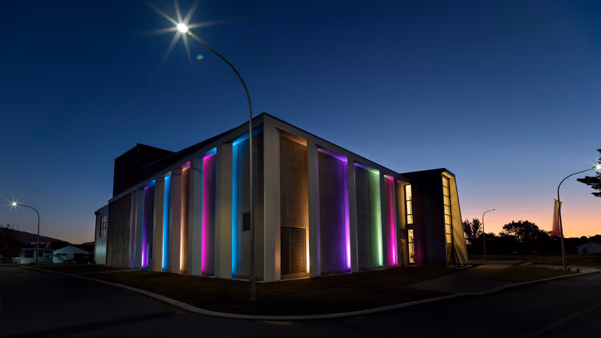 Fachada contemporánea con columnas iluminadas en morado verde y amarillo