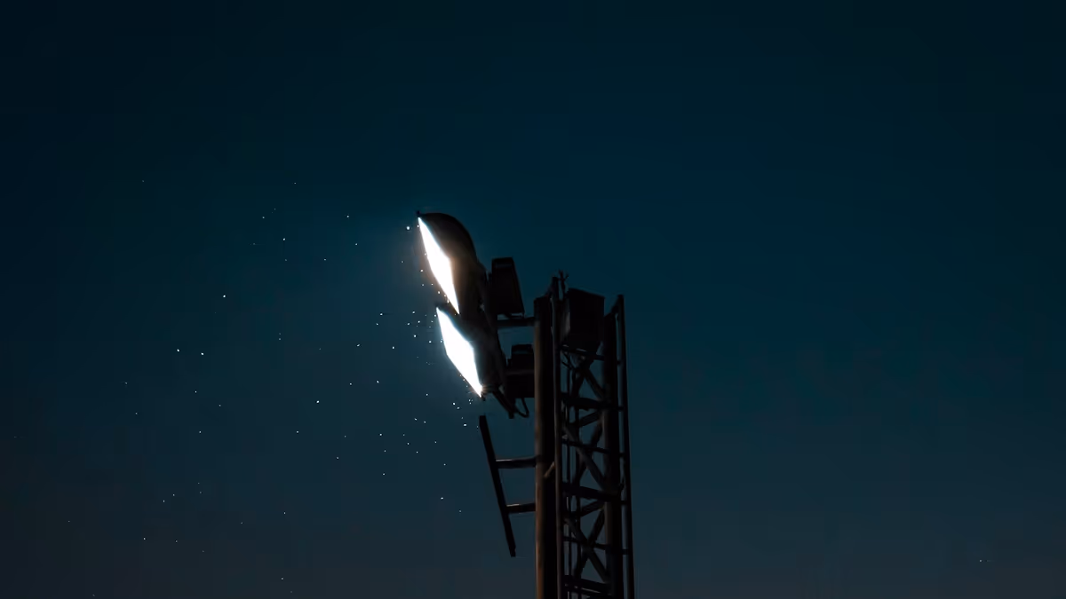 Reflector de alta potencia encendido en lo alto de una torre metálica por la noche