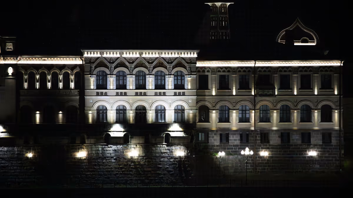 Edificio ornamentado con ventanas arqueadas iluminado durante la noche