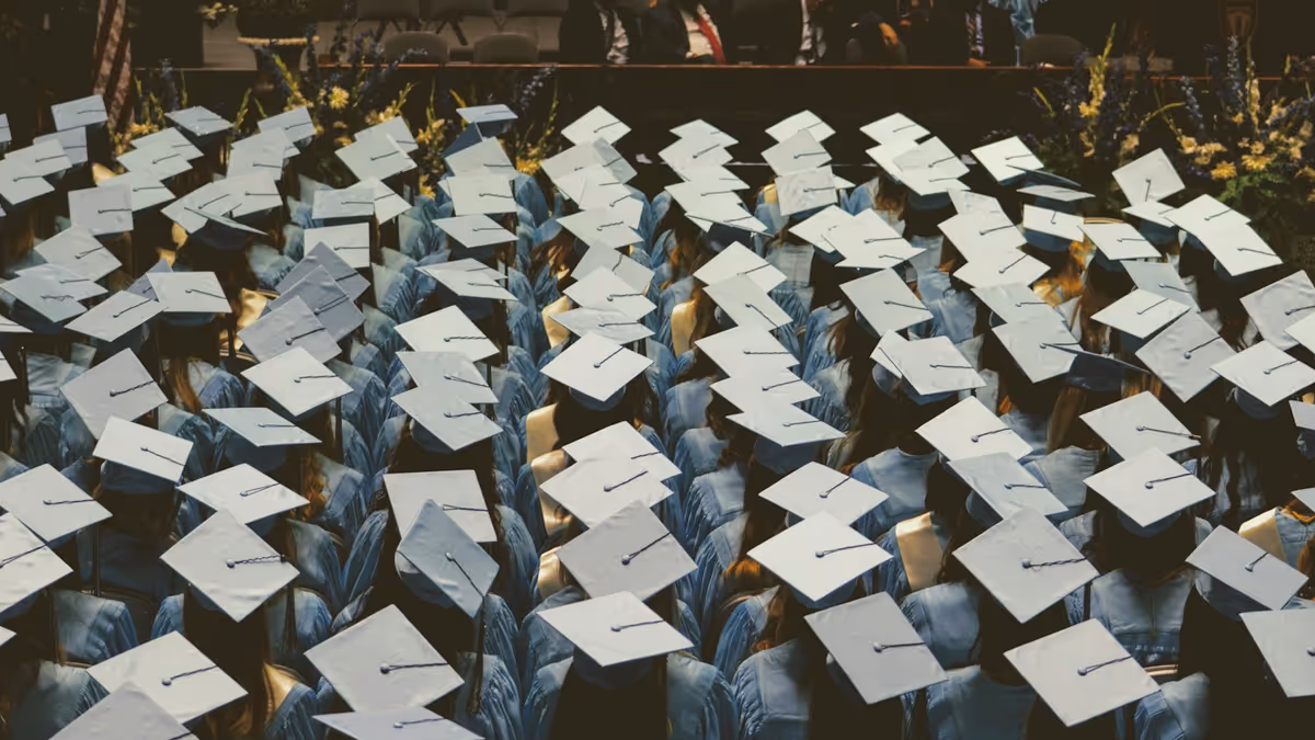 Grupo numeroso de graduados con togas y gorros azul claro en ceremonia