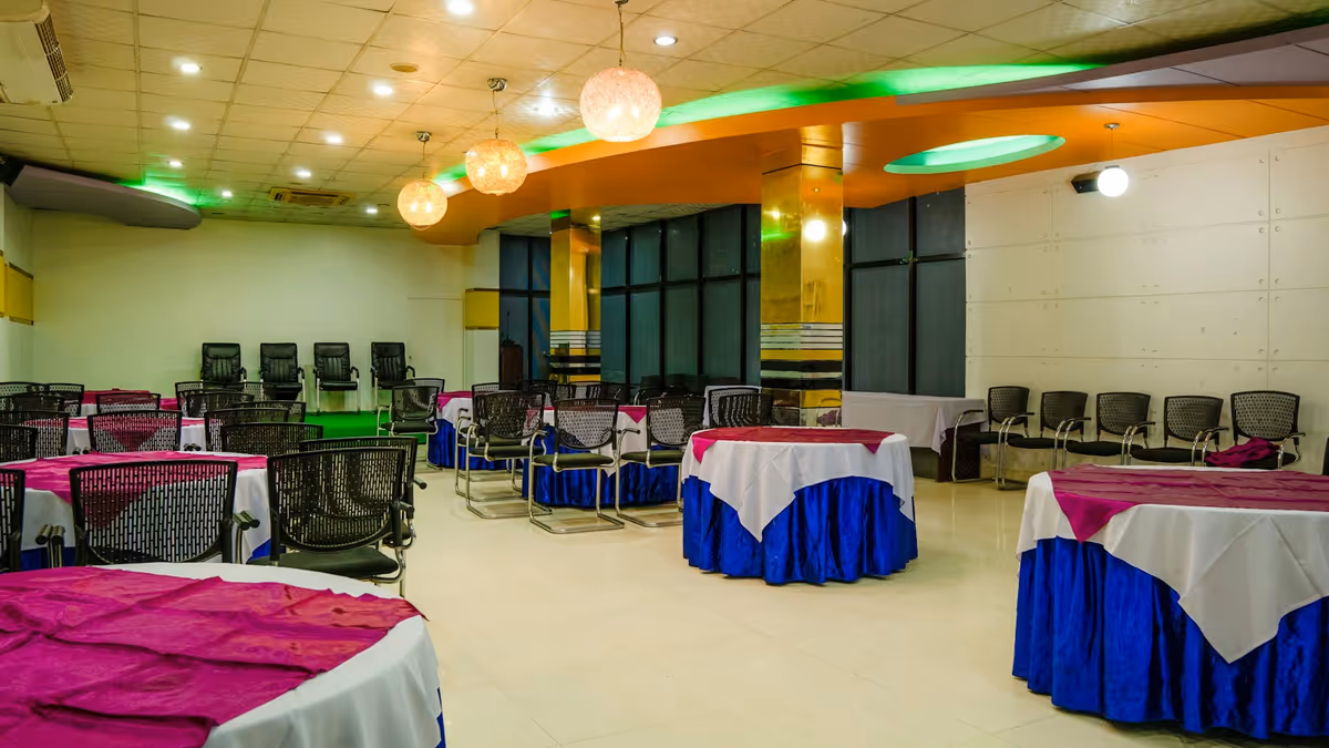 Mesas redondas con telas blancas y azules en salón para eventos