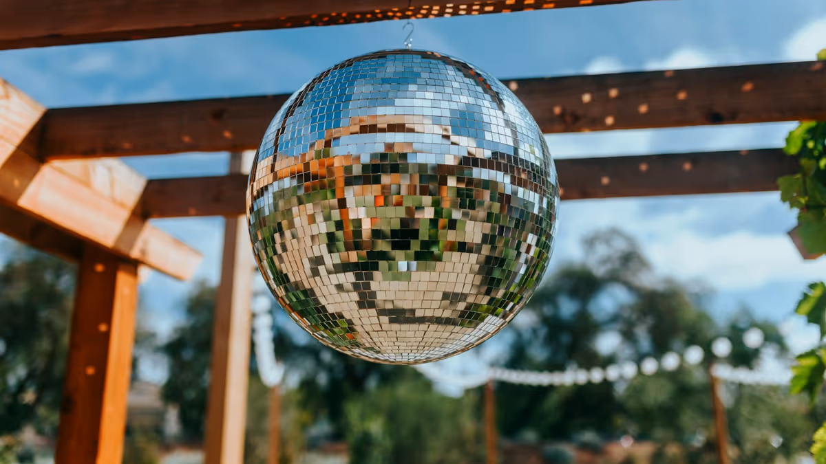 Bola de discoteca colgando de una pérgola de madera