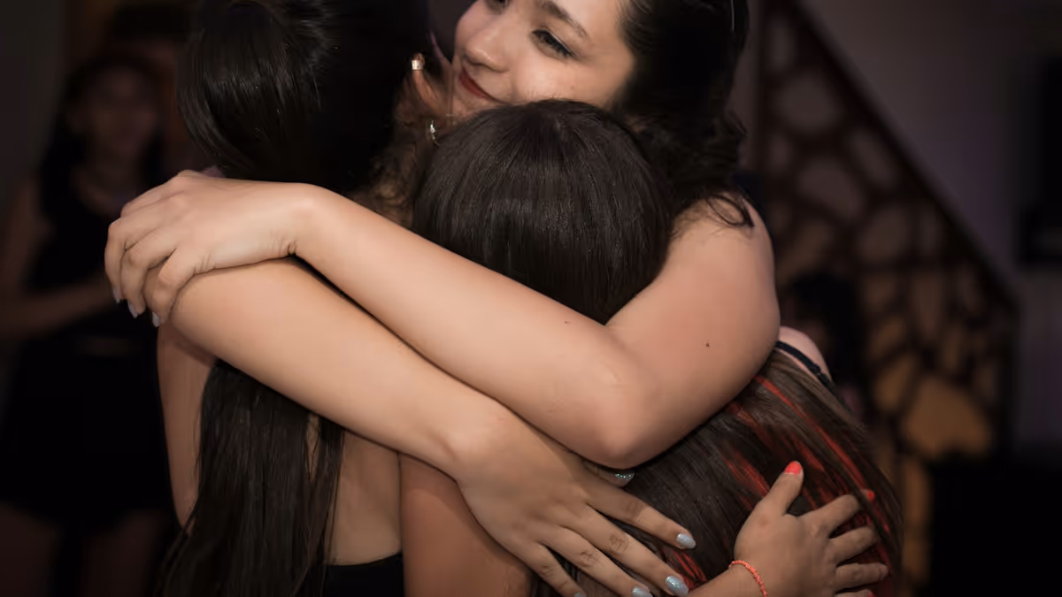 Dos mujeres abrazándose durante una fiesta con ambiente de celebración