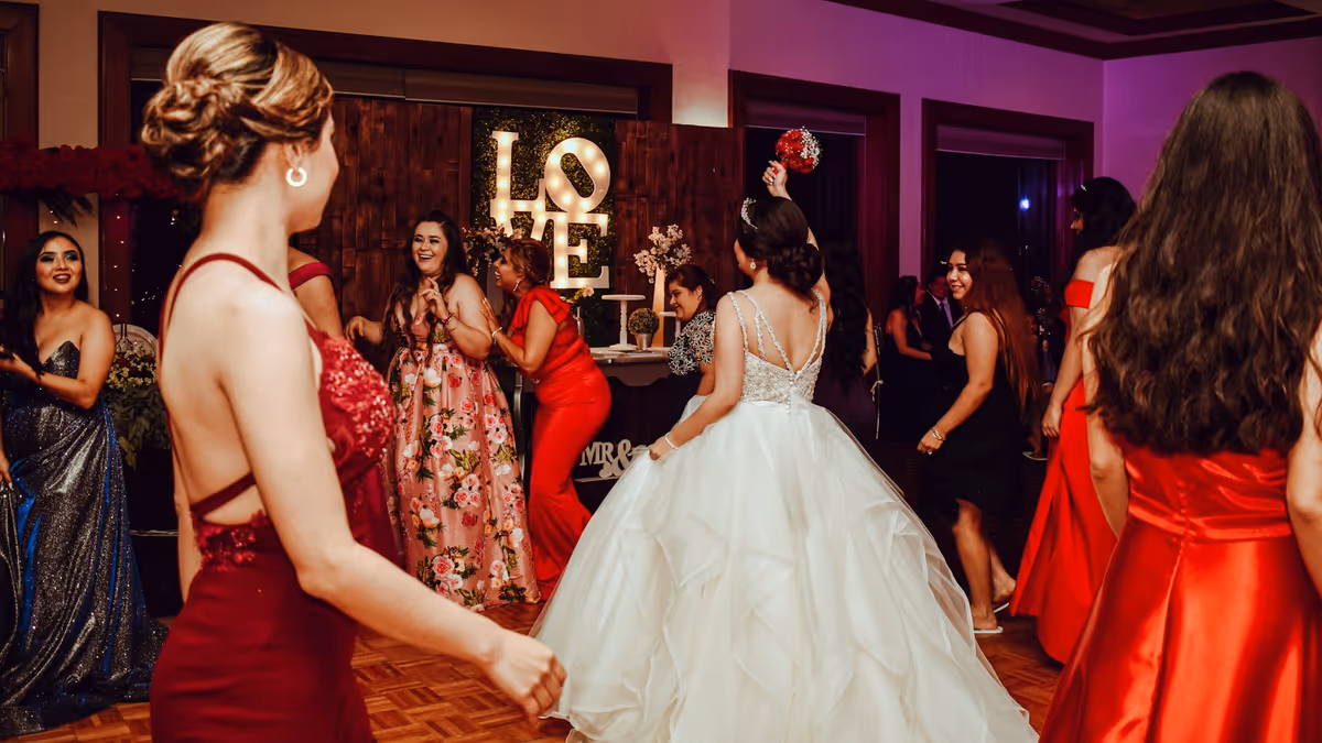 Personas bailando en evento formal junto a letrero de amor
