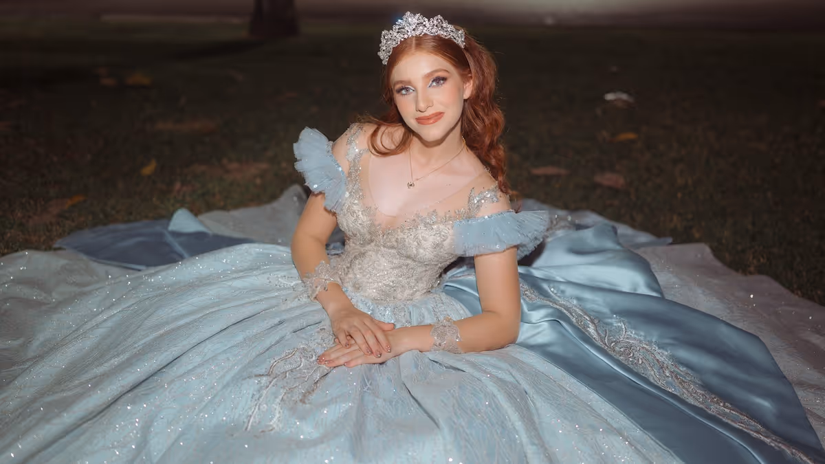 Joven con vestido de princesa azul y tiara durante sesión de XV años