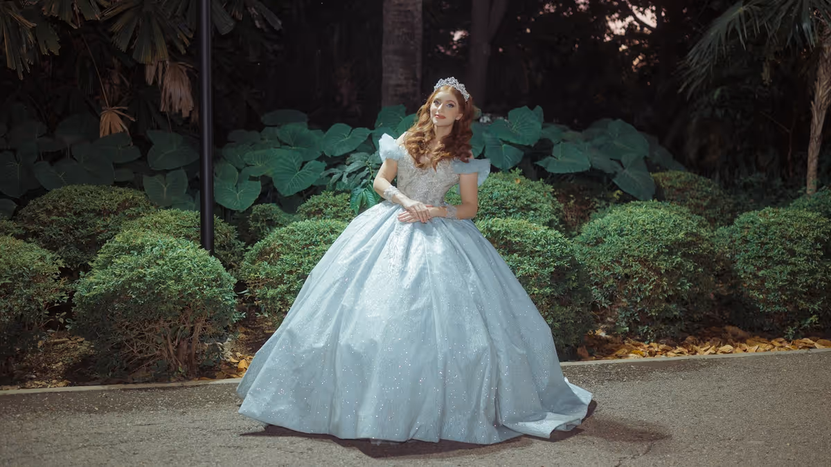 Mujer con vestido azul de gala en jardín para sesión de XV años