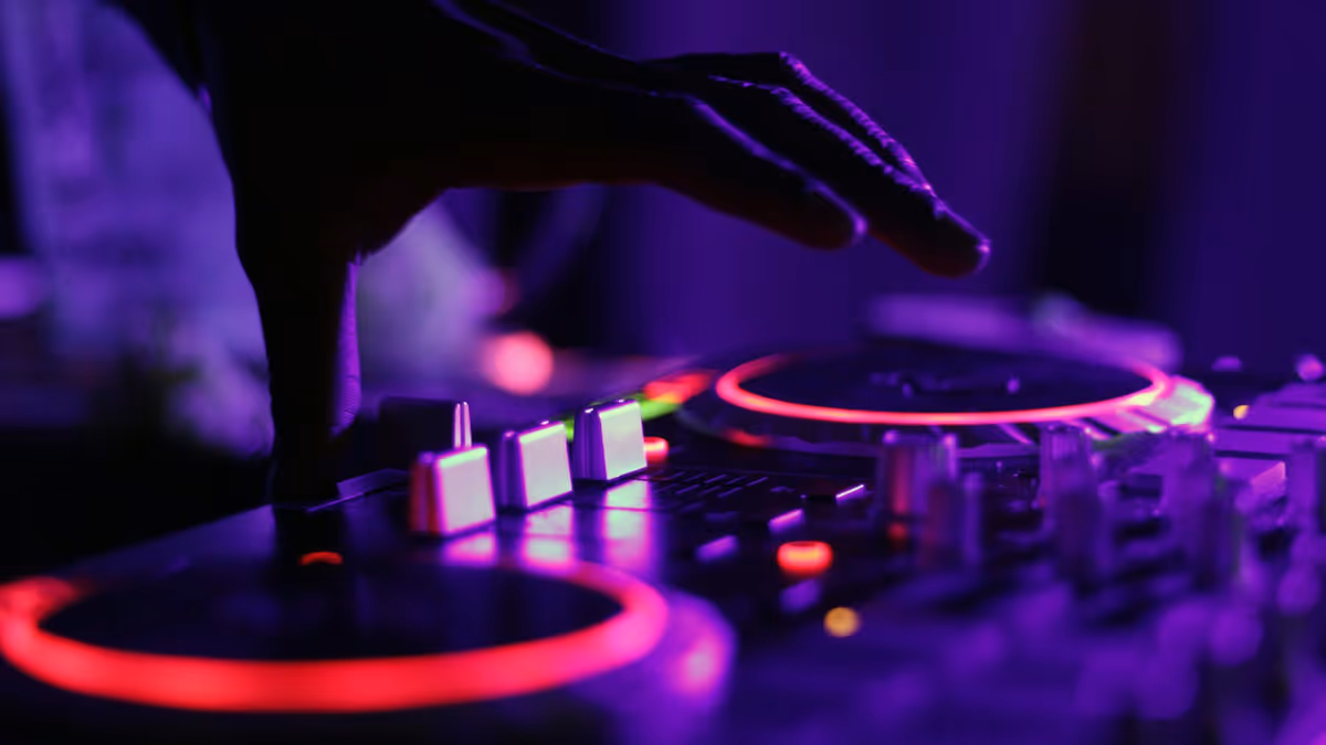 Silueta de DJ en cabina iluminada por luz roja intensa