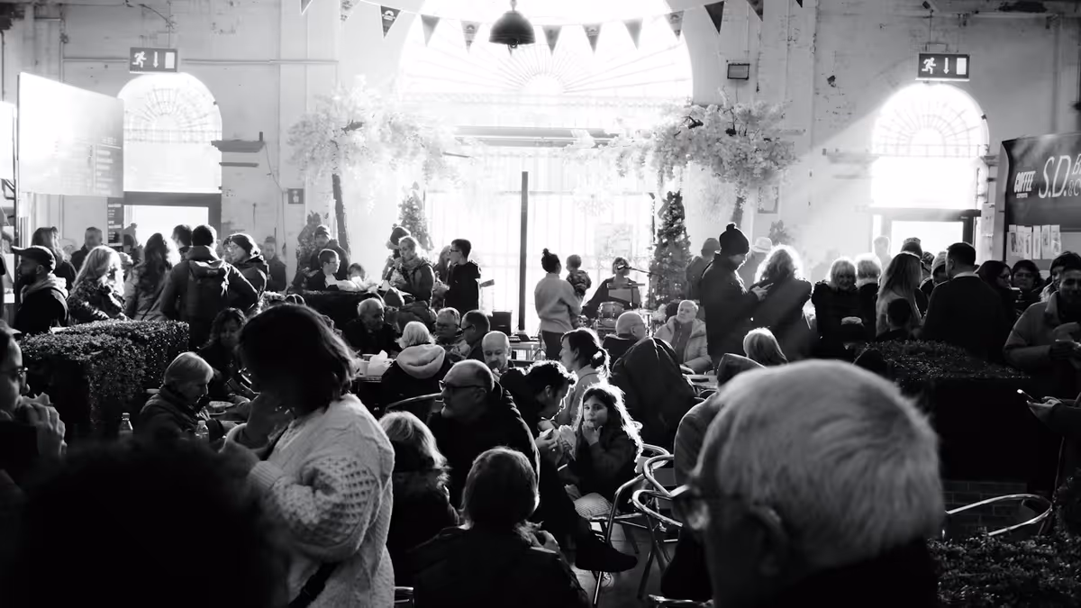 Multitud reunida en un gran salón decorado antes del momento del confeti