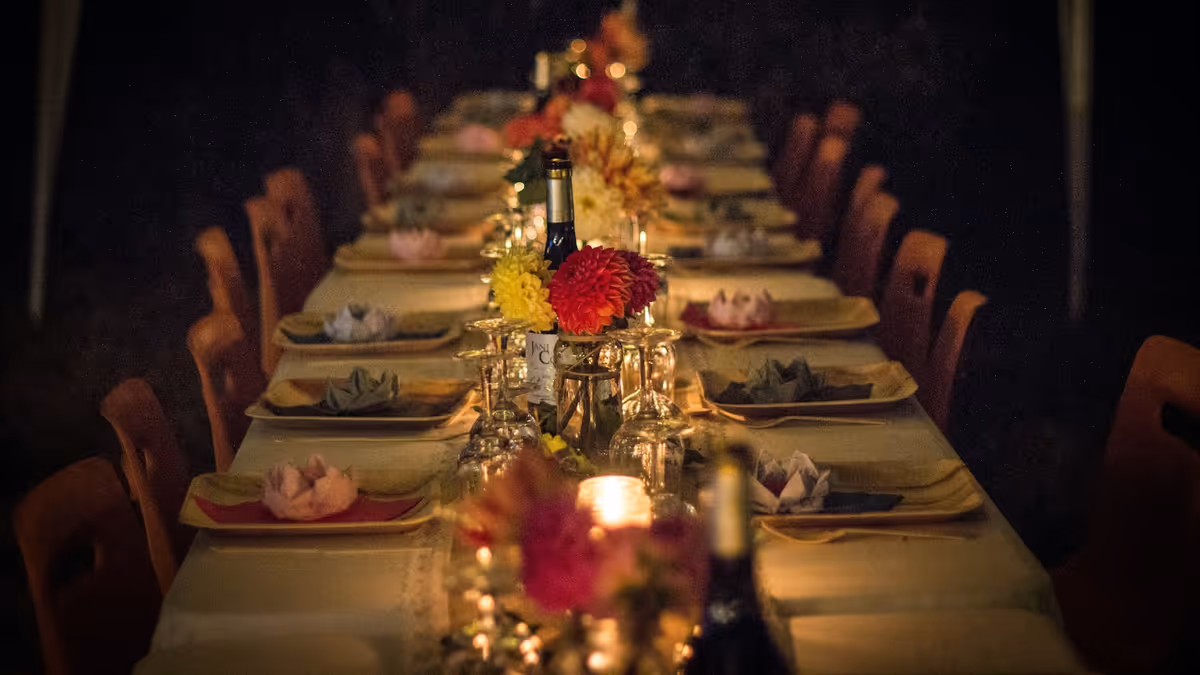 Mesa larga de cena con flores y velas para aniversario
