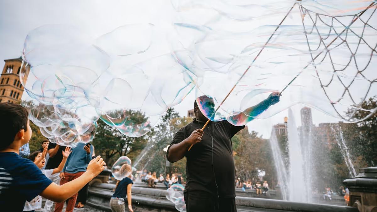 Hombre y niño creando arte con burbujas junto a una fuente durante el día
