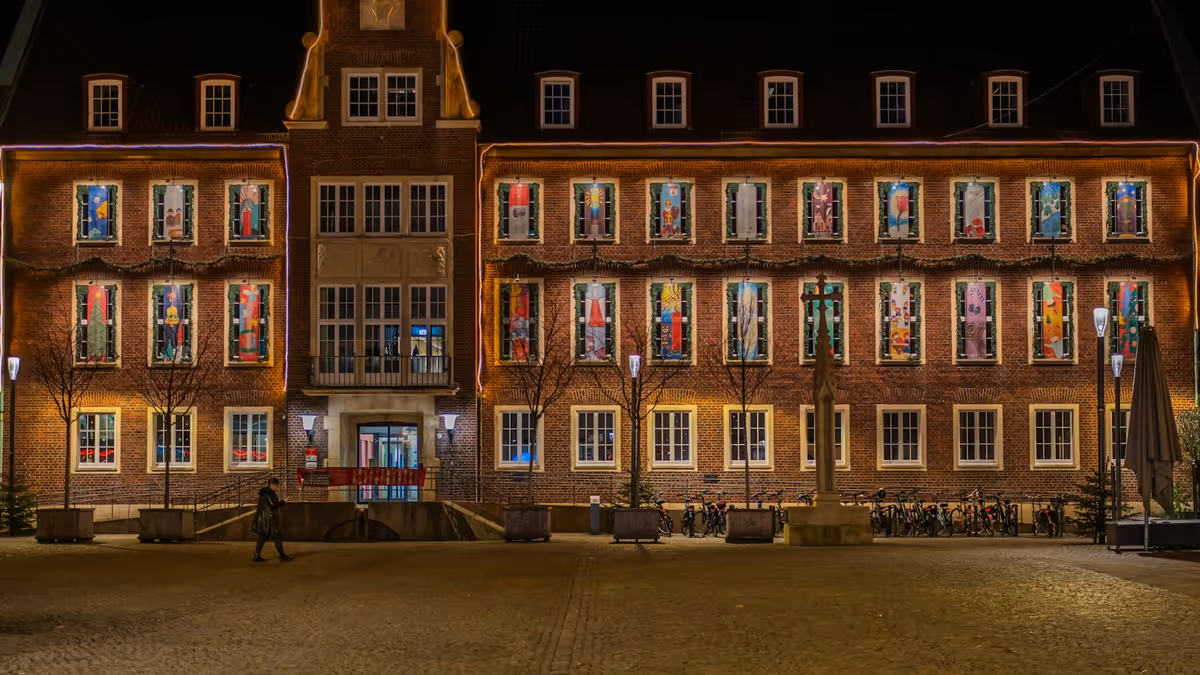 Edificio histórico con ventanas iluminadas de colores durante la noche
