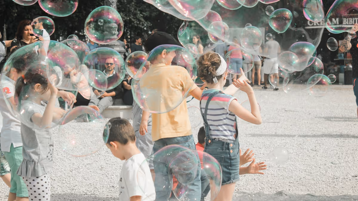 Niños jugando entre pompas de jabón durante una fiesta infantil