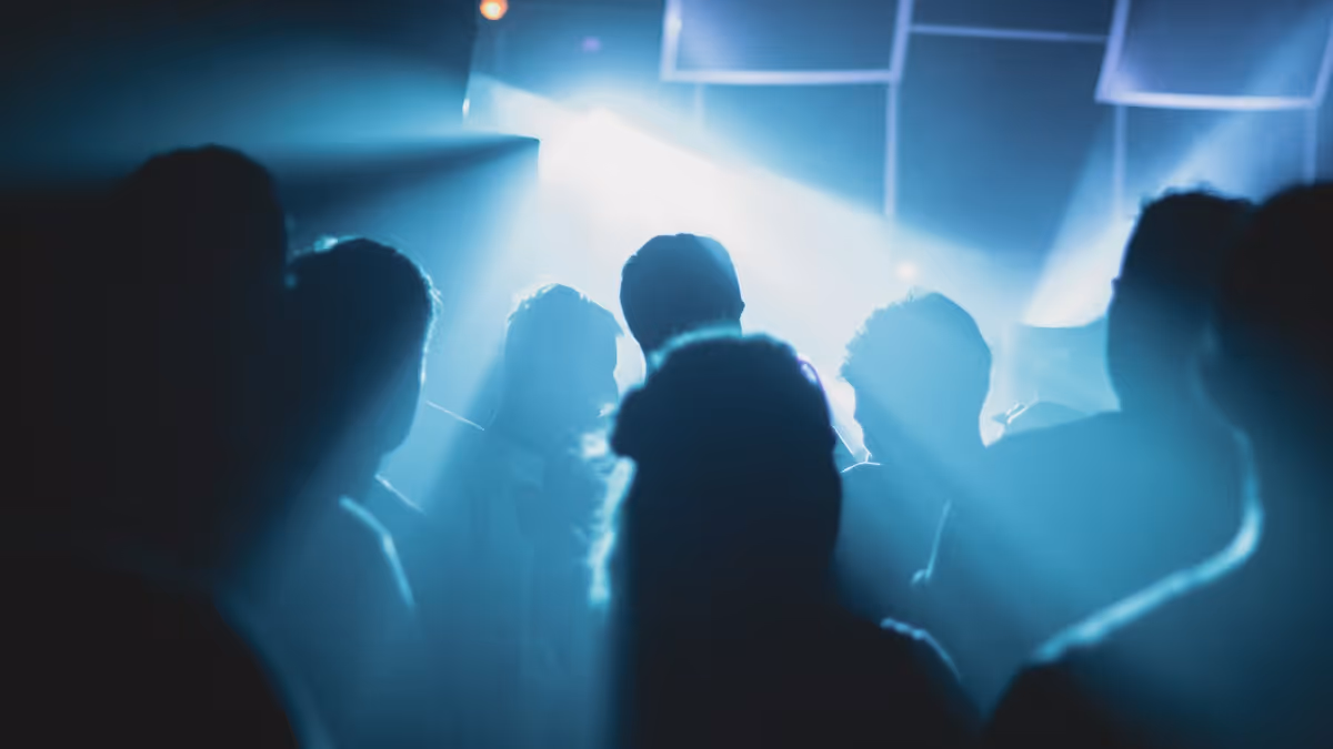Grupo de personas reunidas dentro de habitación durante una fiesta