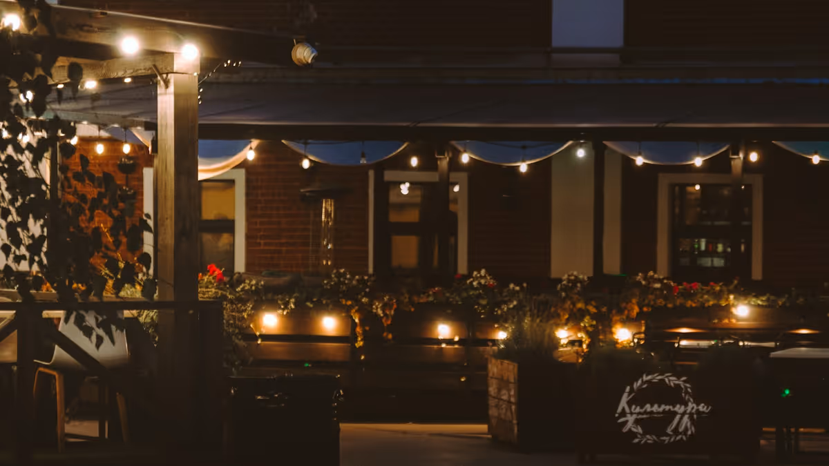Área de asientos exterior nocturna con luces de cadena en terraza