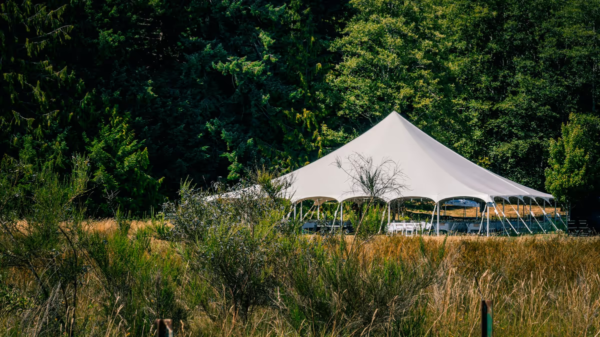 Carpa blanca instalada en campo de hierba para evento exterior