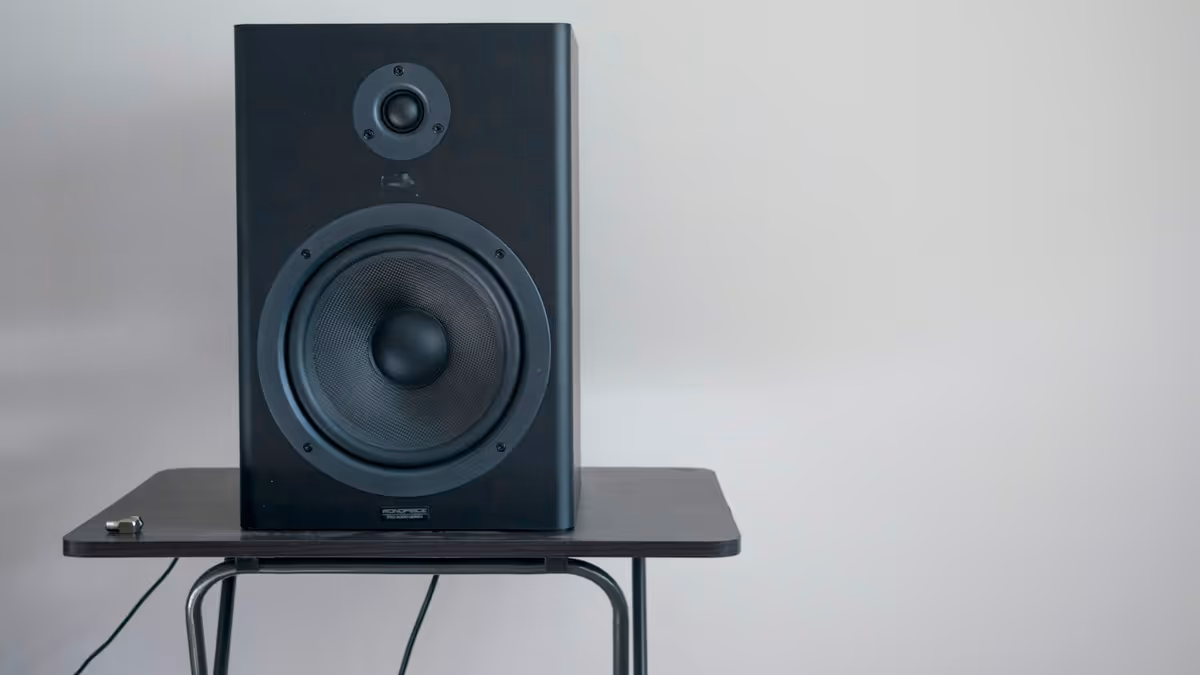 Altavoz negro sobre una mesa durante preparación de presentación