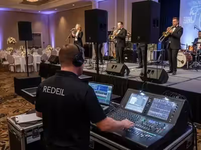 Ingeniero en la mezcladora durante set de banda en vivo