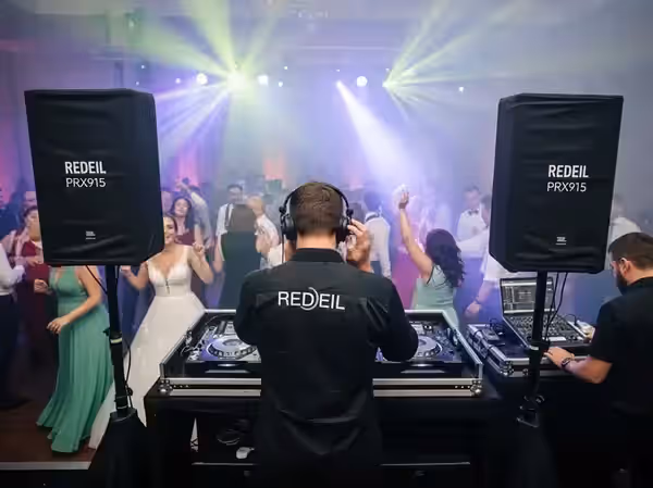 Cabina de DJ en salón de hacienda iluminado con candil