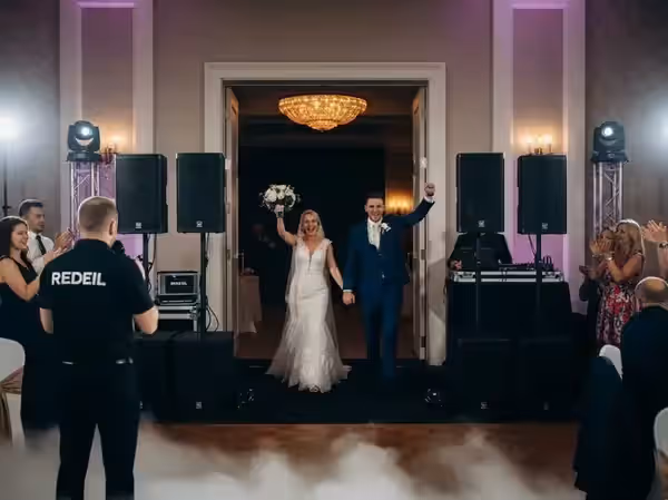Invitados aplaudiendo la entrada de los novios al salón