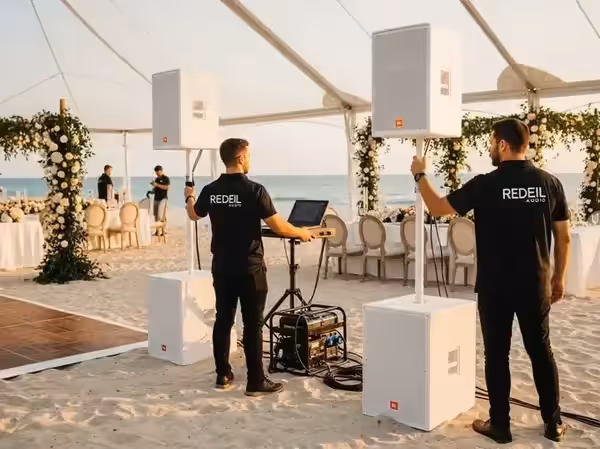 Instalación de bocinas JBL blancas en boda de playa