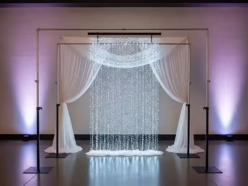 Arco de ceremonia respaldado por una de las dos cortinas LED en tono morado