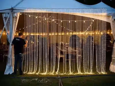 Fondo de luces bajo carpa exterior para fotos de invitados por la noche