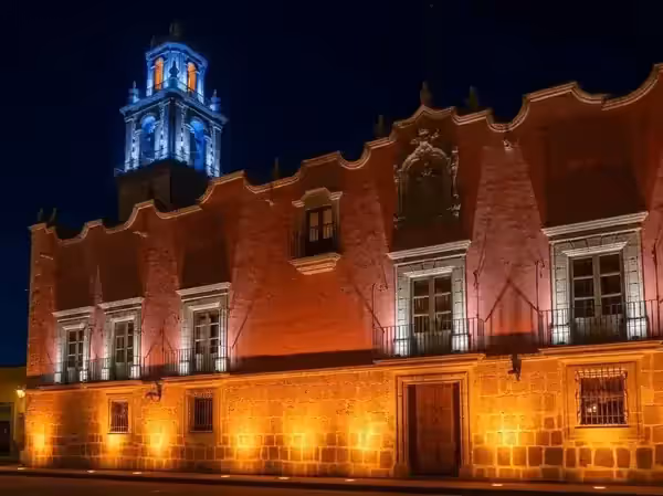 Edificio histórico con la fachada iluminada de noche durante un evento