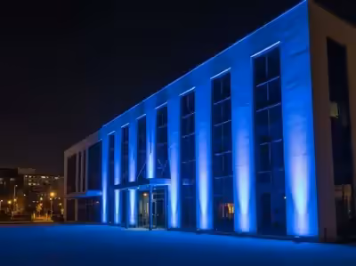 Fachada de edificio moderno bañada en azul desde la distancia