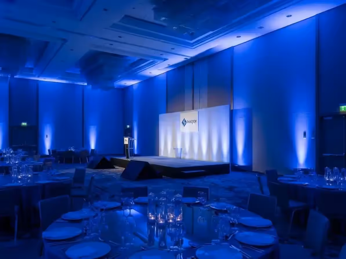 Congreso empresarial con muros y escenario en azul de marca