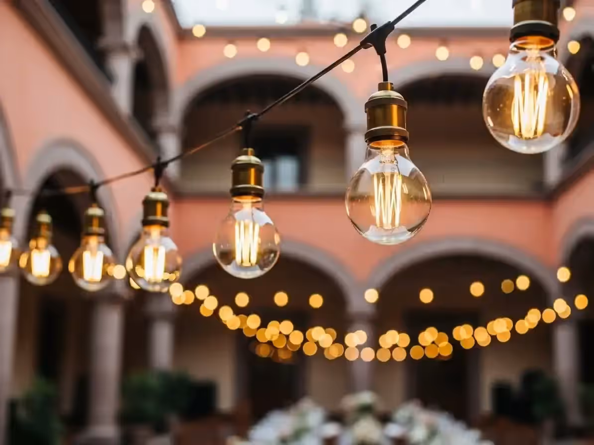 Guirnaldas iluminando evento social nocturno con focos decorativos