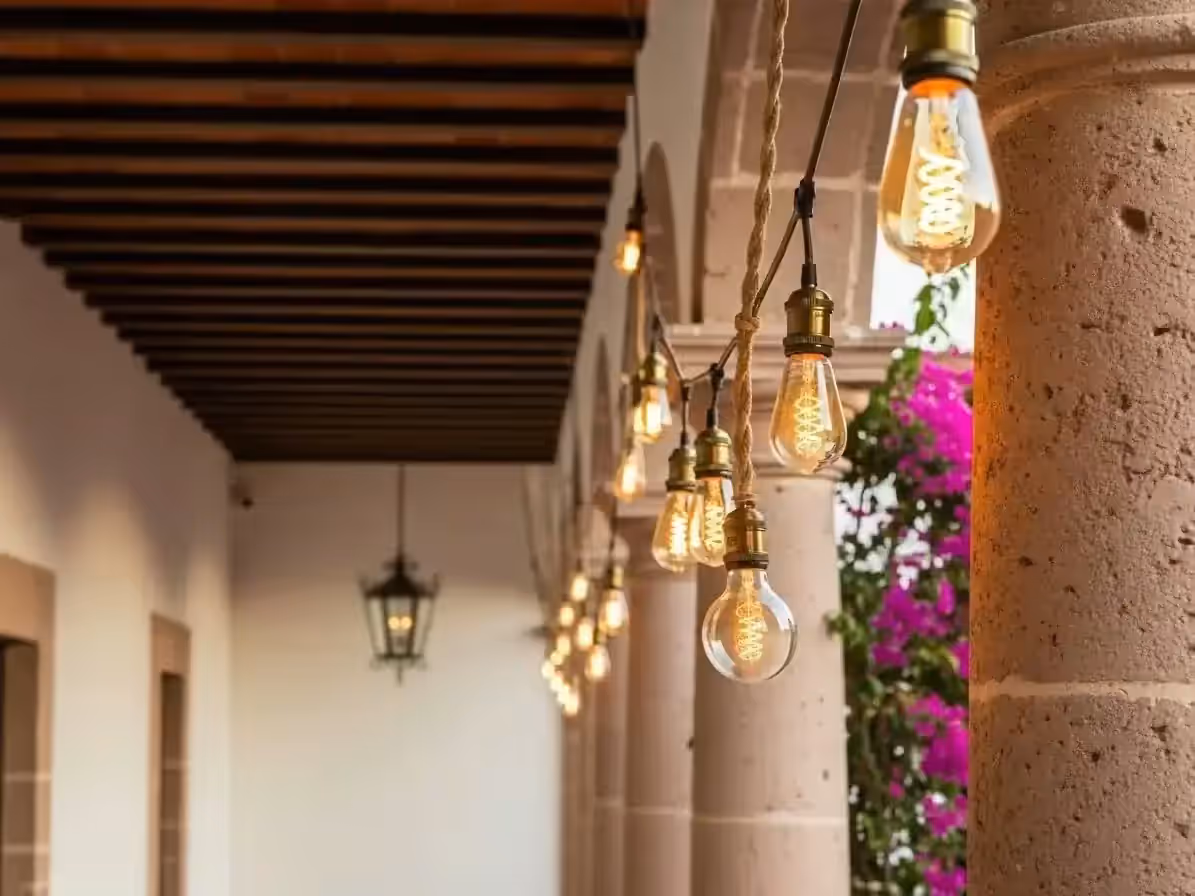 Focos Edison vintage colgados en corredor colonial de hacienda para evento