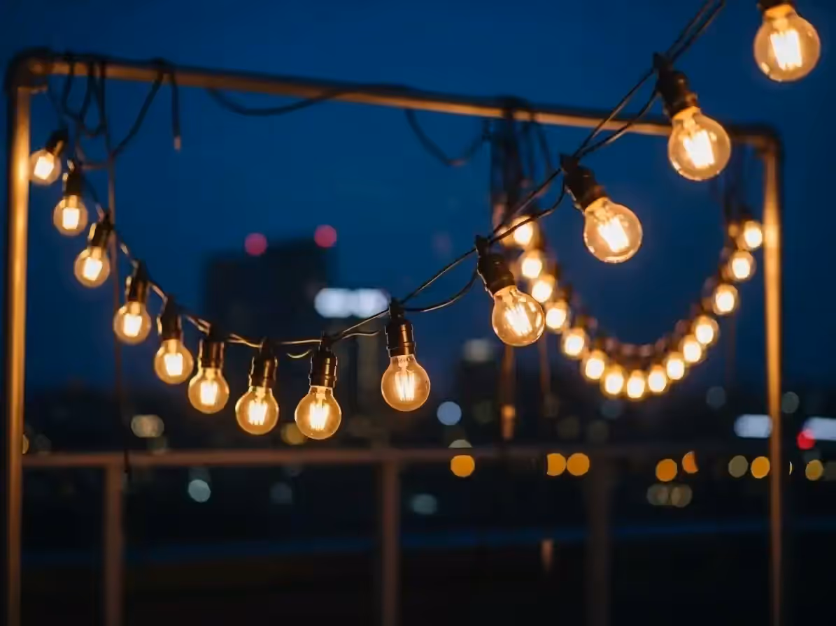 Guirnaldas de luz ámbar en evento de noche al aire libre