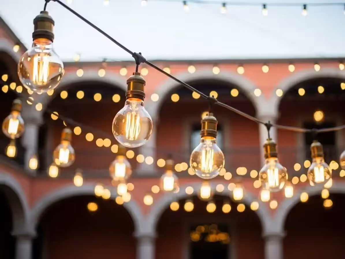 Guirnaldas de luz cálida instaladas en terraza para recepción