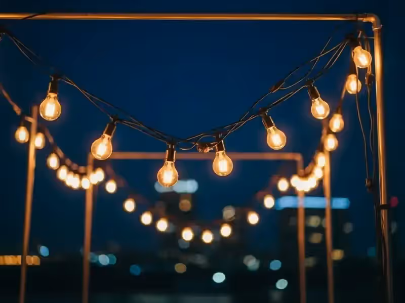 Guirnaldas Edison en rooftop con vista a la ciudad para evento nocturno