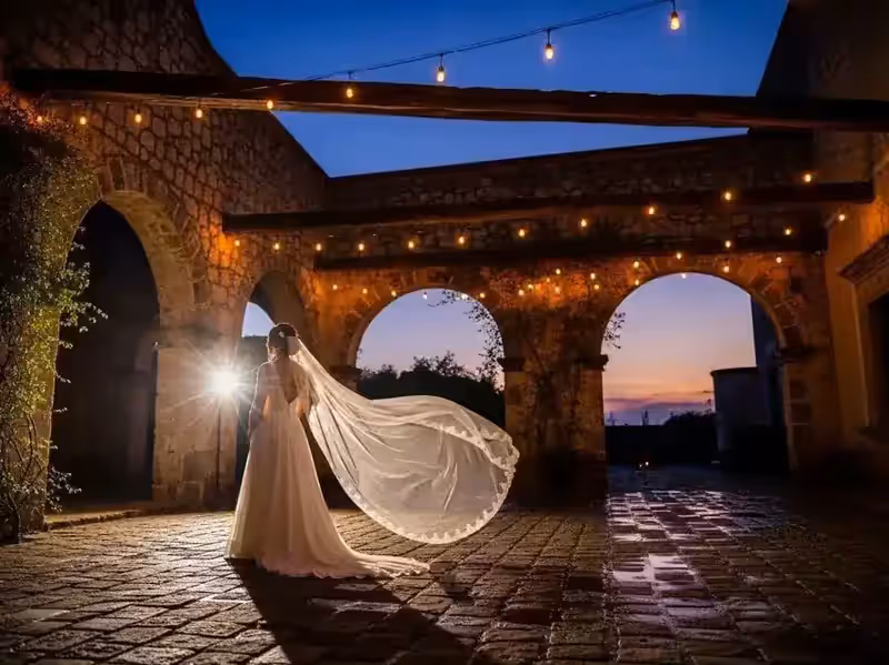 Novia bajo arcos de piedra con guirnaldas tendidas