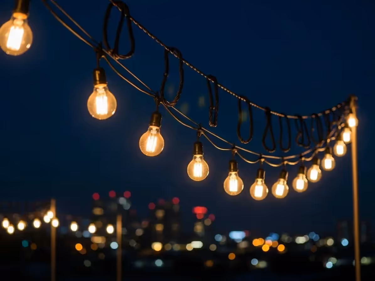Serie de focos Edison con luz cálida iluminando evento en terraza