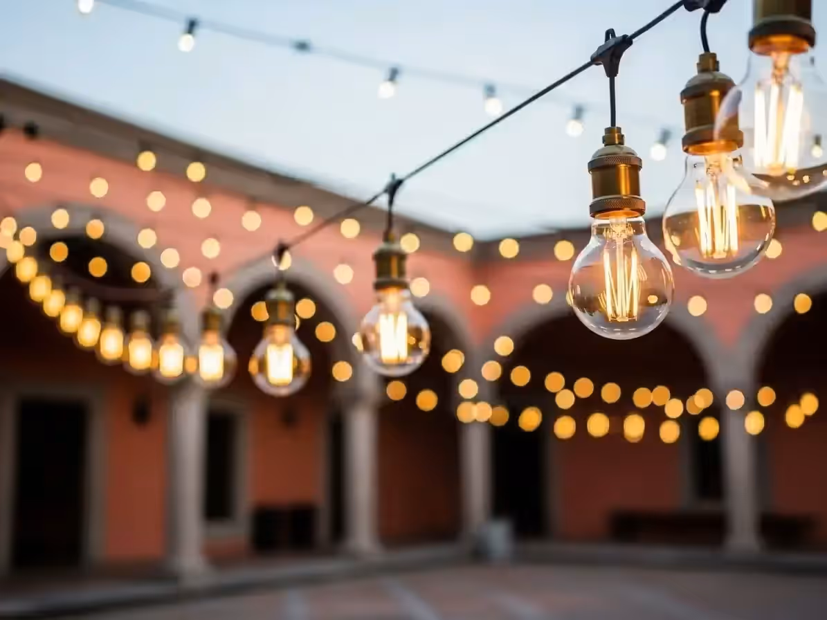 Luces vintage tendidas en patio de hacienda