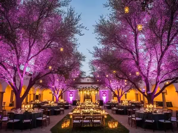 Árboles en morado detrás de las mesas de una boda al aire libre con velas