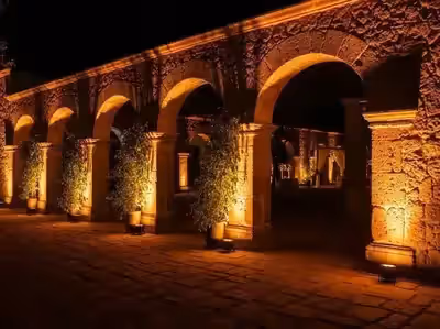 Arcada de hacienda iluminada con luz ámbar en evento social