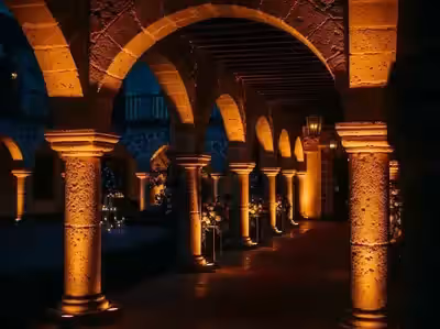 Arcos y columnas de piedra en luz cálida iluminados con seis unidades