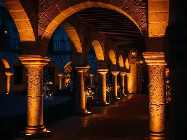 Cantera de arcos y columnas realzada con luz cálida rasante