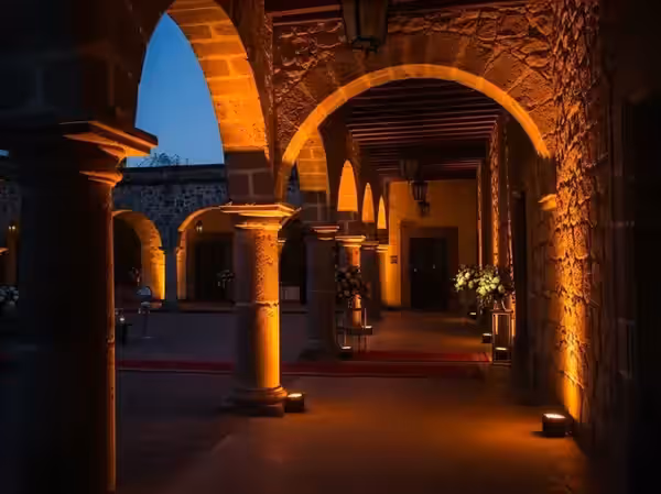 Corredor colonial de cantera iluminado en ámbar
