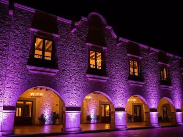 Fachada de hacienda colonial en morado durante un evento de noche
