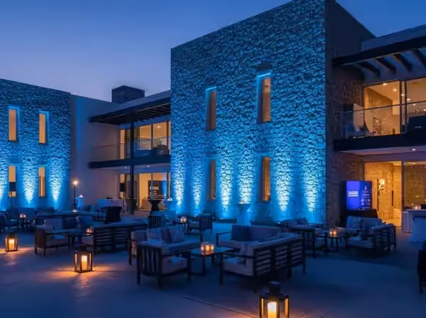 Fachada moderna iluminada en azul para evento corporativo