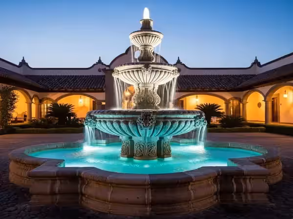 Fuente de patio colonial iluminada en turquesa